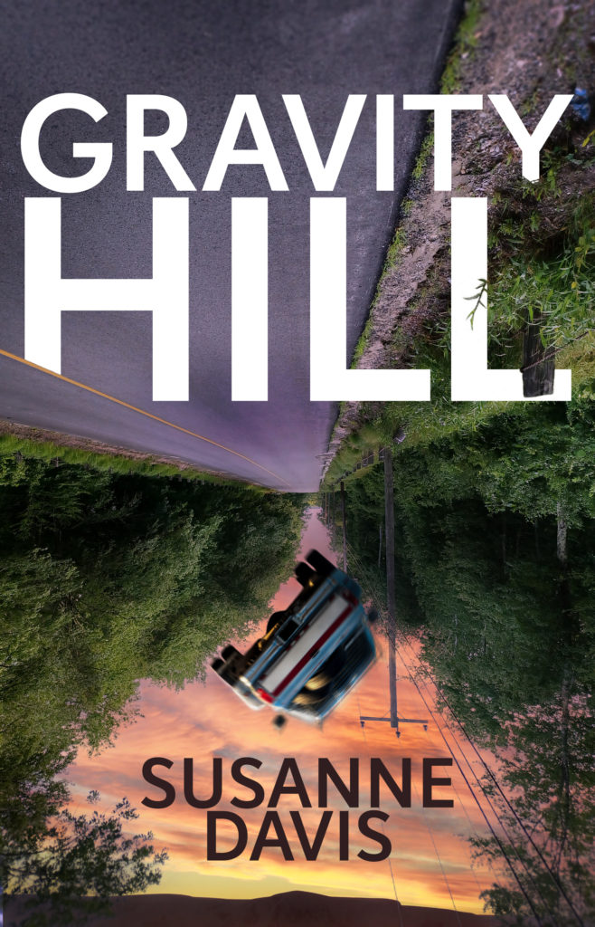 Gravity Hill, a novel by Susanne Davis. Front cover shows a road turned upside down with a pickup truck falling off or it.